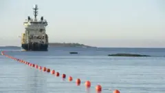 海底ケーブルを敷設する船と海に浮かんだブイ