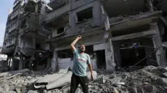 A resident shouts around destroyed buildings and debris at the Al-Karama neighborhood after an Israeli airstrike that has been going on for five days in Gaza City, Gaza on October 11, 2023