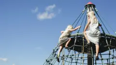 Duas meninas escalam um brinquedo em um playground