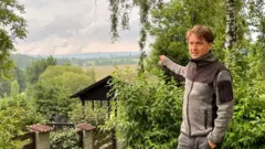 Milan Starec pokazuje na termoelektranu Turov preko granice