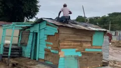 ቤት የሚጠግን ሰው ጣሪያ ላይ