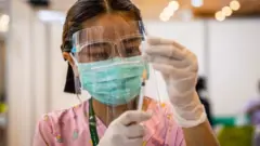 ကာကွယ်ဆေးထိုးပေးဖို့ပြင်နေတဲ့ သူနာပြုတစ်ဦး