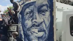 La moitié du visage de George Floyd apparaît lors d'un rassemblement à Paris