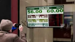 Una pizarra mostrando el dólar en 60 pesos.