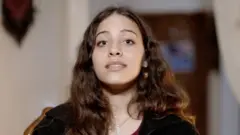جنه تمیمی بر صندلی نشسته