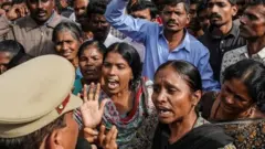 People argue with police over a protest against the alleged rape and murder of a 27-year-old woman