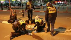 İsrail'de bir alışveriş merkezi yakınında bıçak ve araçla yapılan saldırı sonrası polis yerde delil arıyor