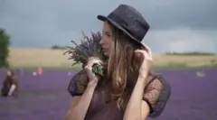 Devojka pozira za fotografiju na polju lavande