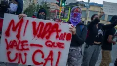 Manifestantes protestan con un cartel en contra de un CAI.