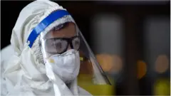 ফেসশিল্ড পরা একজন ব্যক্তি