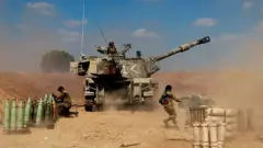 Israeli soldiers fire towards the Gaza Strip on 13 May