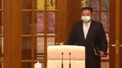김정은 위원장이 정치국 회의에 마스크를 쓰고 참석하는 장면