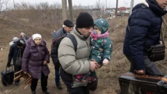 Residents of Irpin flee heavy fighting via a destroyed bridge