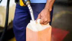Frentista enche frasco com gasolina