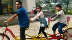 দুই সন্তানকে নিয়ে খেলছেন একজন বাবা