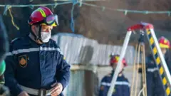 Rescuer looks into the hole