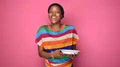 Une femme en sourire tenant une assiette