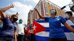 Manifestantes pró-governo seguram bandeira de Cuba em ato em Havana