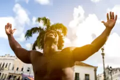 Homme au torse nu levant les bras au ciel