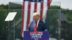 Donald Trump kurşun geçirmez camın ardından konuşuyor
