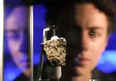 Um jovem observa um meteorito em uma exposição no Museu de História Natural de Londres