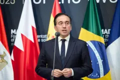 José Manuel Albares ülkelerin bayrakları önünde konuşma yapıyor.