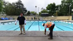 Dos trabajadores comienzan el mantenimiento y las reparaciones en la piscina de la escuela secundaria South Pasadena el 16 de mayo de 2015 en South Pasadena, California.