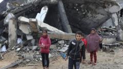 破壊された建物の前に立つ子供たち（ガザ地区）