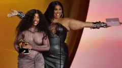 Lizzo (iburyo) yashyikirije SZA igihembo cy'indirimbo nziza ya R&B 