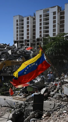 Una bandera venezolana ondea en medio de los escombros que dejaron los terremotos en Venezuela. 