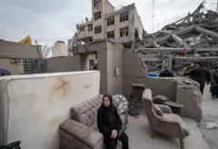 सोमवारी अमेरिका-इस्रायलच्या लष्करी मोहिमेदरम्यान निवासी भागात झालेल्या हल्ल्यात उद्ध्वस्त झालेल्या घराच्या बाहेर हताशपणे सोफ्यावर बसलेली इराणी महिला