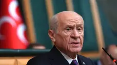 Devlet Bahçeli arkasında MHP üç hilal bayrağı ile mecliste konuşurken