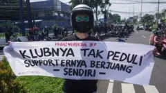 Seorang pengunjuk rasa membawa spanduk yang menyatakan minimnya dukungan terhadap korban tragedi Kanjuruhan. 