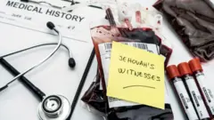 Blood bag wit paper on am and stethoscope beside am 