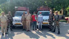 पुलिसकर्मी पकड़े गए लोगों के साथ