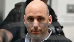 Підсудний чоловік з невеликою щетиною за склом