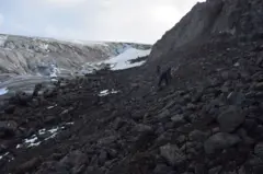 Várias rochas e no fundo uma geleira
