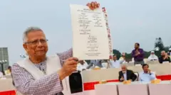 O líder do governo interino, Muhammad Yunus, está segurando a cópia assinada da Declaração Nacional de Julho de 2025