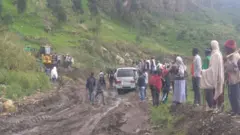 በአስቸጋሪ መንገድ ላይ ያለ ተሽከርካሪ እና ተሳፋሪዎች 