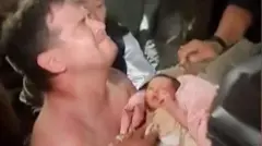 Um homem sem camisa, visivelmente emocionado, segura um bebê que acaba de ser retirado dos escombros de um edifício destruído pelos terremotos na Venezuela