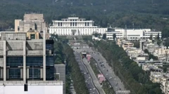 نمایی از یک خیابان بلند دو بانده با ساختمان‌هایی در اطراف، و یک ساختمان بزرگ و سفید در انتهای آن