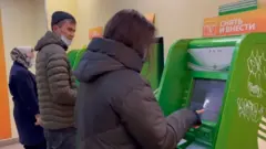 Москвадаги банкоматдан нақд пул олаётган ўзбекистонлик мигрантлар