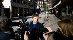 Halktan biri kendisine çevrilmiş kameralara konuşuyor, arkada olayın yaşanddığı barın uzaktan görüntüsü var.