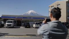 富士山とコンビニの写真を撮る外国人観光客