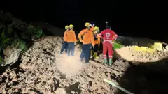 Объединенная поисково-спасательная группа вместе с местным сообществом по-прежнему прилагает максимум усилий для поиска жертв, которые подозреваются в том, что они были погребены под оползнем.