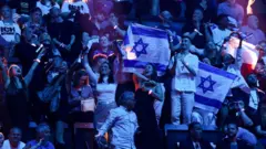 Pessoas seguram bandeiras de Israel durante a segunda semifinal do Festival Eurovision de 2025.