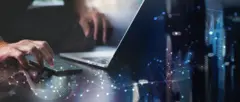 Detalhes de mãos teclando em um laptop com efeitos representando tráfego de informações pela internet