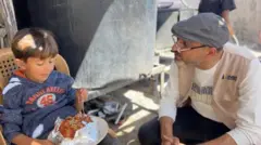 Sami Matar junto a un niño que come