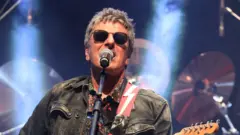 Mesquita de olhos escuros e tocando guitarra durante show