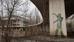 Grafites no Palácio da Cultura Enerhetyk, abandonado na praça central de Prypiat, no oblast de Kiev, na Ucrânia, em 12 de abril de 2025